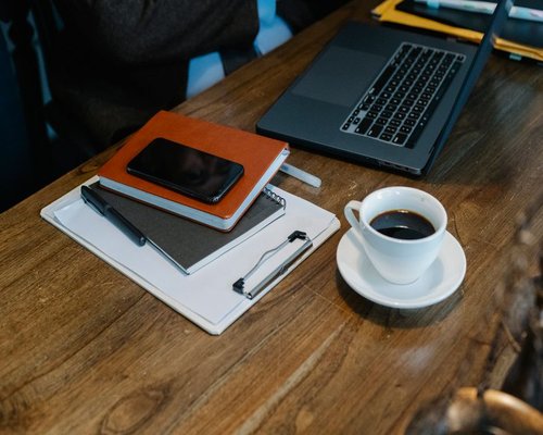 A cup of coffee and a notebook on an office desk in Jakarta