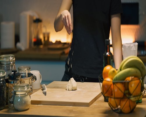 A person cutting fruits mindfully in a cozy kitchen